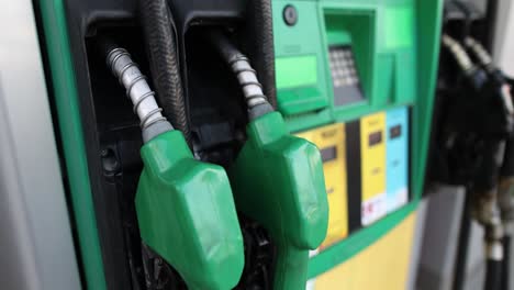 close-up of green gas pump nozzles at a station