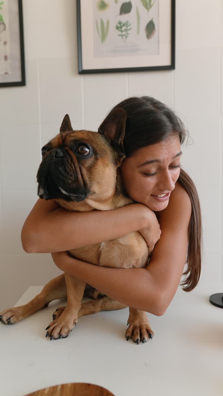 A woman hugging her French Bulldog