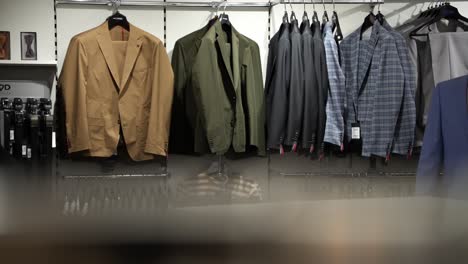 men's suits and blazers on display in clothing store