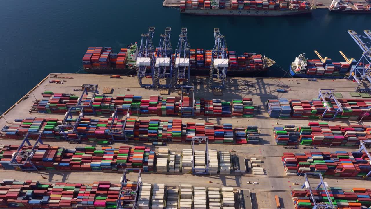 Porto merci trafficato con container impilati e attività delle gru