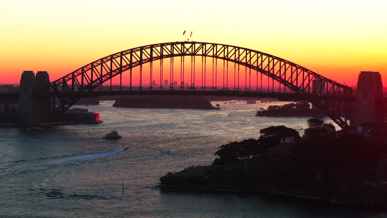 Golden hour sunset Sydney Harbour Bridge Circular Quay wharf ferry boats Australia aerial drone Kurraba Point Mattawunga scenic helicopter flight orange yellow sun reflection static shot