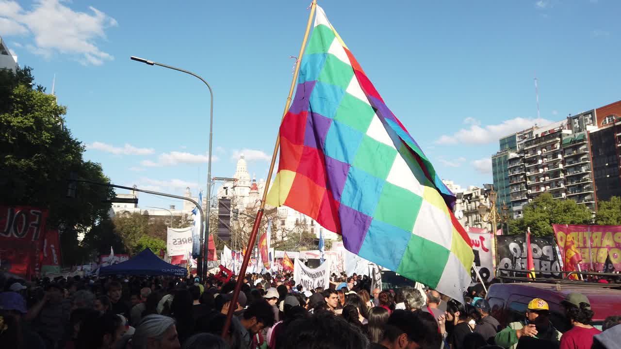 Wiphala flag waves in massive people march square emblem commonly used as a flag to represent some native peoples of the Andes