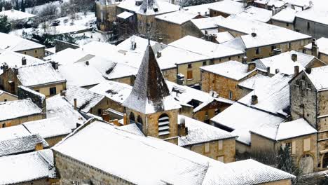 teleobiettivo aereo vista della chiesa monpazier in inverno sotto la neve, strade vuote, piazza del mercato visibile, dordogne, francia