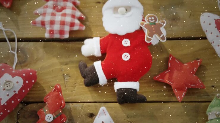 Video composition with falling snow over desk with christmas decorations