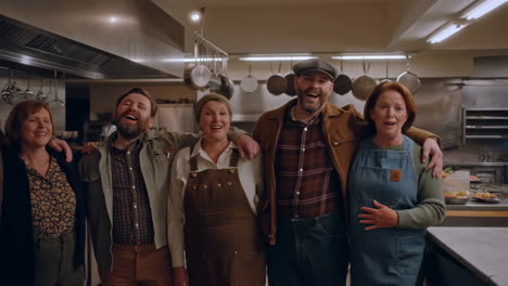 a joyful group of people gathered in a commercial kitchen