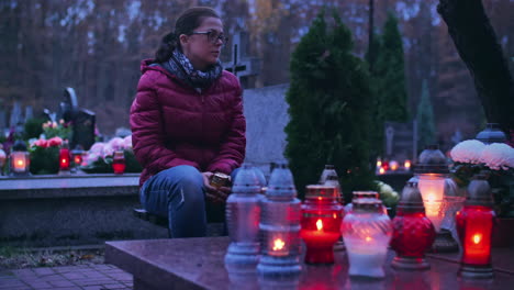 Woman-sitting-at-a-grave-of-her-deceased-ones-in-the-evening