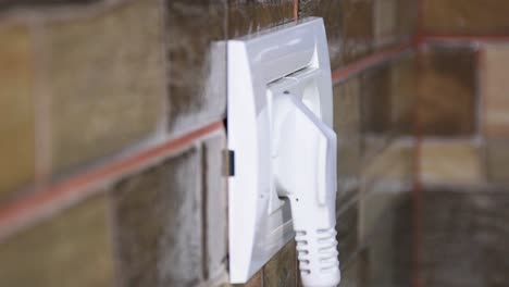 side view of woman hand plugging and unplugging from the wall power socket