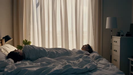 couple sleeping in a bright bedroom