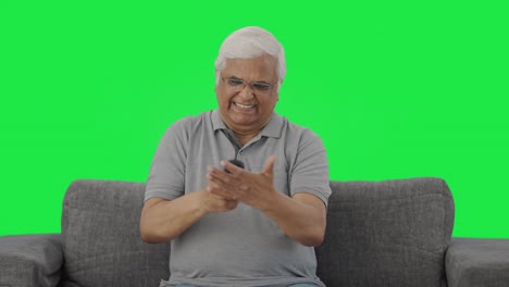 Angry-Indian-old-man-trying-to-fix-TV-Remote-Green-screen