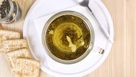 green tea with jasmine is brewed, leaves move in cup in circle