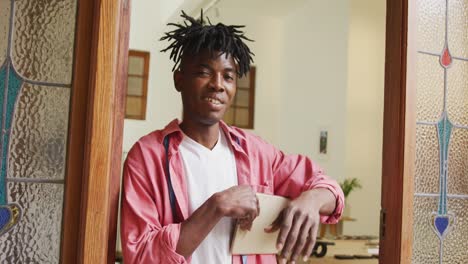 happy african american craftsman using tablet in leather workshop