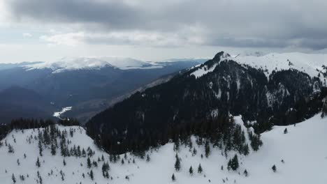 Snowy-Ciucas-Mountains-landscape-with-pine-trees-under-cloudy-skies