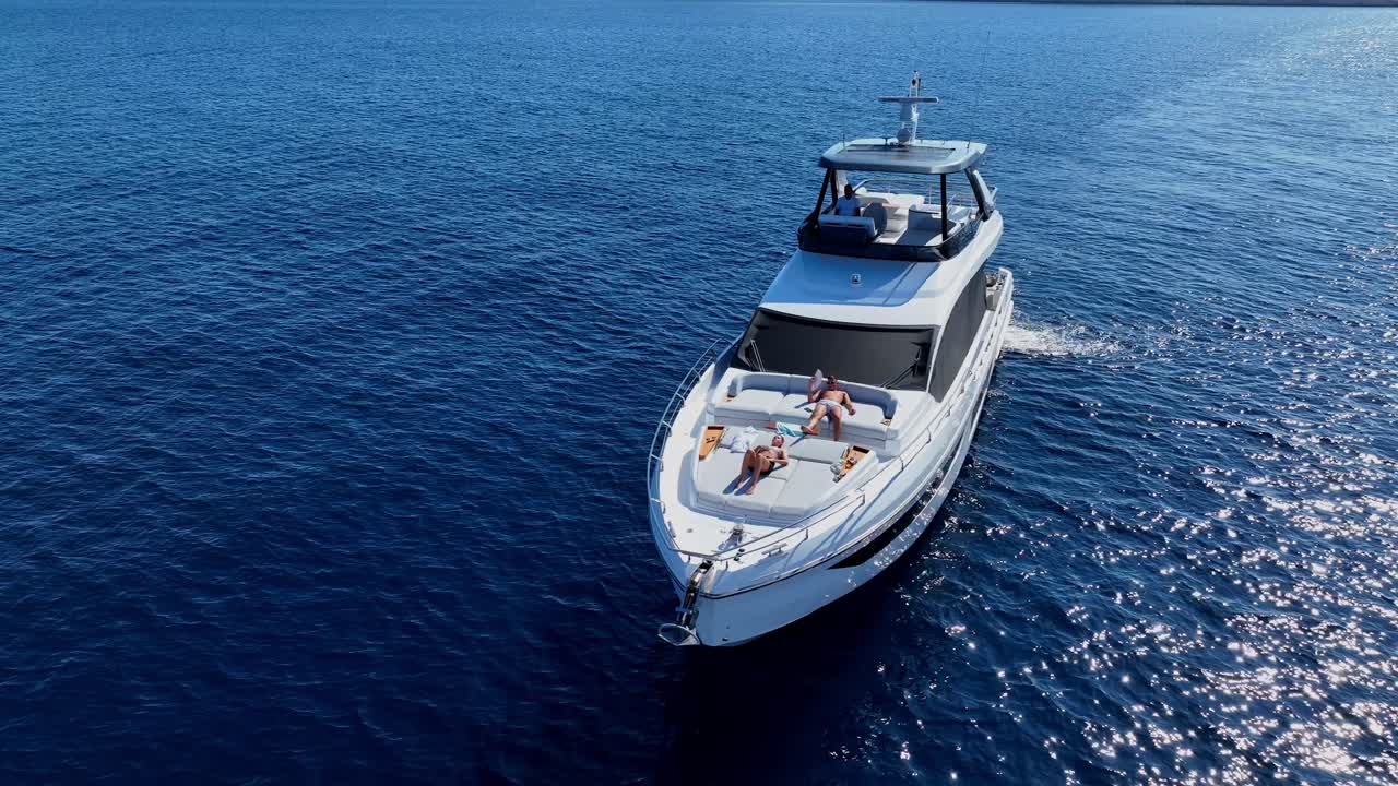 Luxury Yacht at the Sunny Sea with People Relaxing on the Deck AERIAL