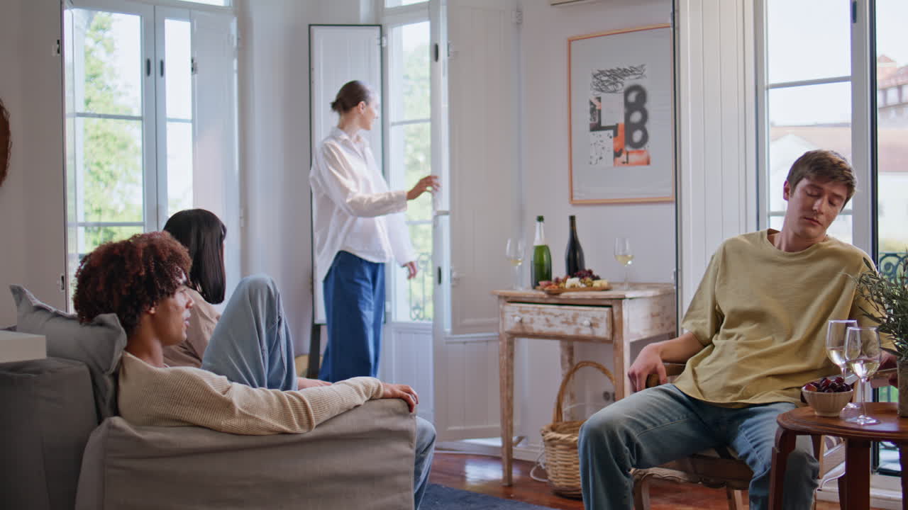 Relaxed mates gathering home talking over drinks sitting at living room together