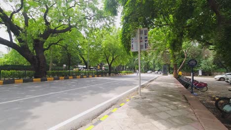 Lapso-De-Tiempo-Fuera-De-La-Entrada-De-Los-Jardines-De-Lodhi-A-Lo-Largo-De-Un-Camino-Con-Hermosos-árboles-Verdes-Y-Tráfico-Intenso