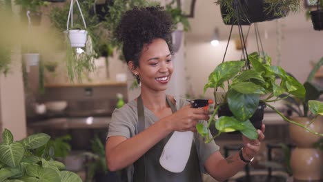 african american woman watering plants in botany shop