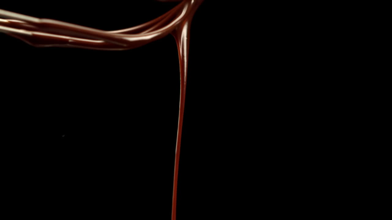 Whisk pouring melted chocolate
