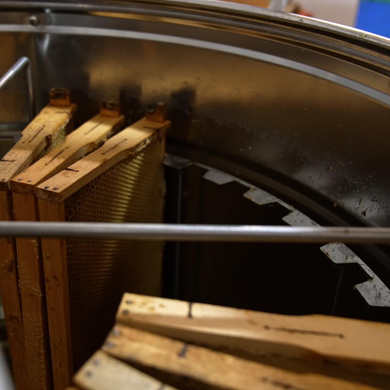Male apiculturist putting the frames into the centrifuge apparatus for honey extraction. Gathering organic product at apiary