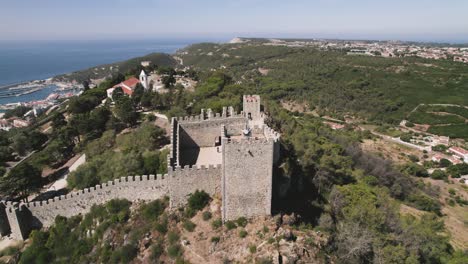 Antena-En-órbita-Sobre-La-Torre-De-Vigilancia-Del-Castillo-De-Sesimbra,-Mirador-Del-Paisaje---Portugal