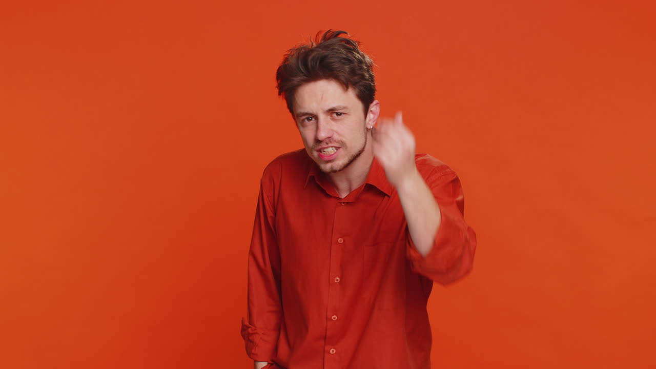 hombre caucásico tratando de oírte mirando confundido y fruncido el ceño manteniendo el brazo cerca de la oreja para una voz más alta