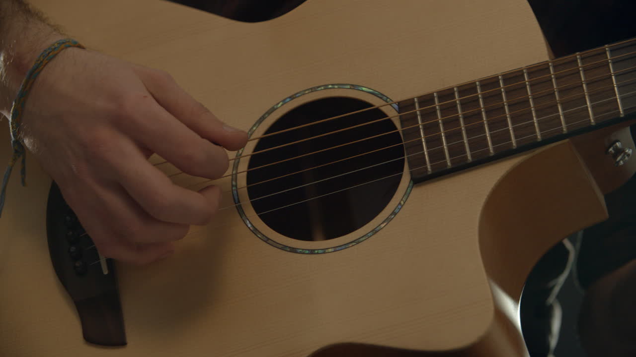 Ujęcie slow motion mężczyzny grającego na gitarze akustycznej