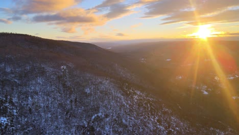 Drone-footage-of-a-forested-mountain-covered-in-light-snow-during-winter-at-dusk-in-the-Appalachian-mountains