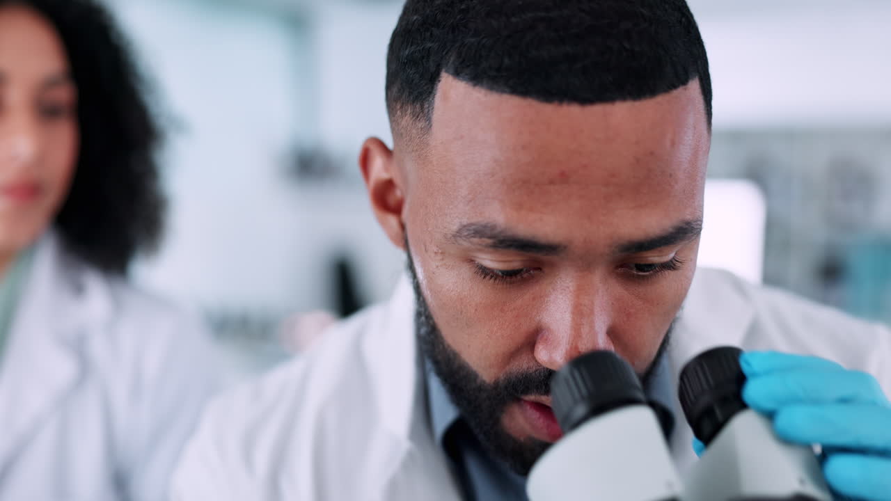 Man, scientist and microscope in laboratory