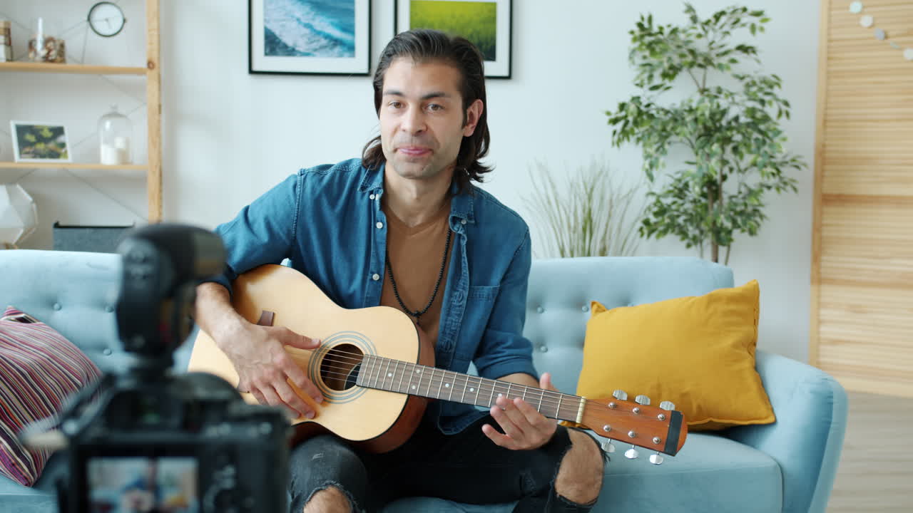 집에서 어쿠스틱 기타를 연주하는 남자