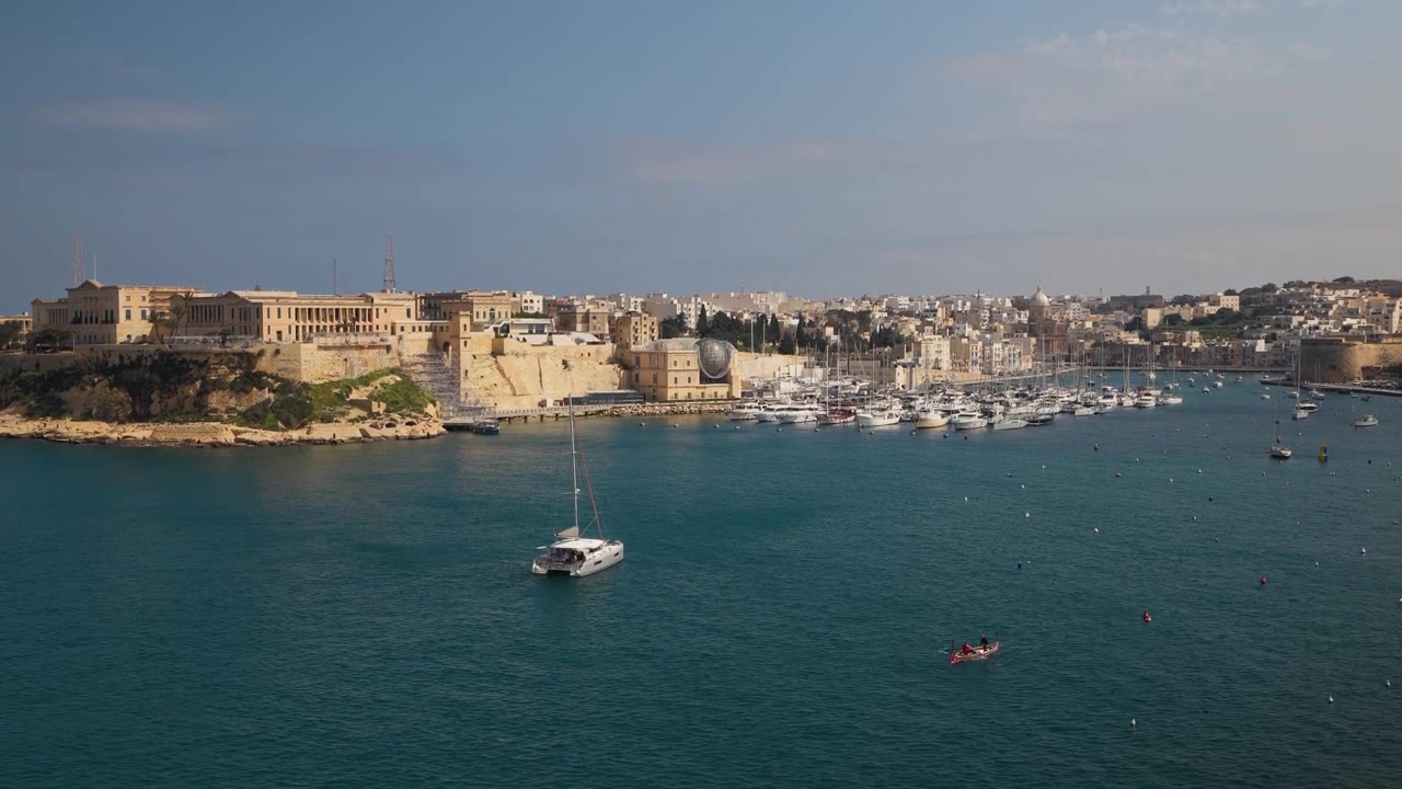 Ampia inquadratura di Kalkara Creek a Malta con Villa Bighi e un catamarano ancorato