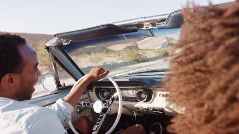 una joven pareja negra en un coche abierto en un viaje por carretera, de cerca