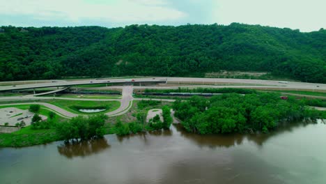 aerial view of interstate 90 crossing through a green landscape near la crosse, minnesota, with nearby river and parking area, and rest area