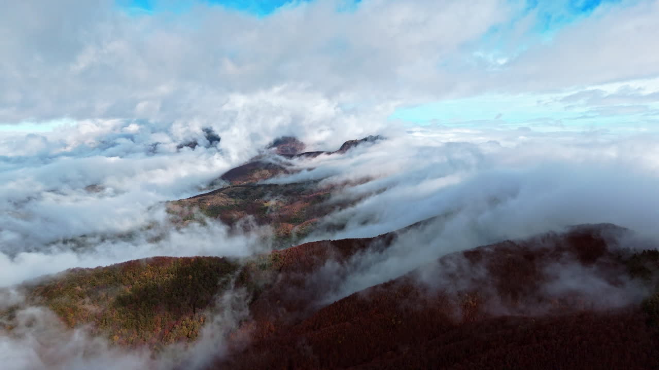 Aerial view of misty mountains with clouds on an autumn day