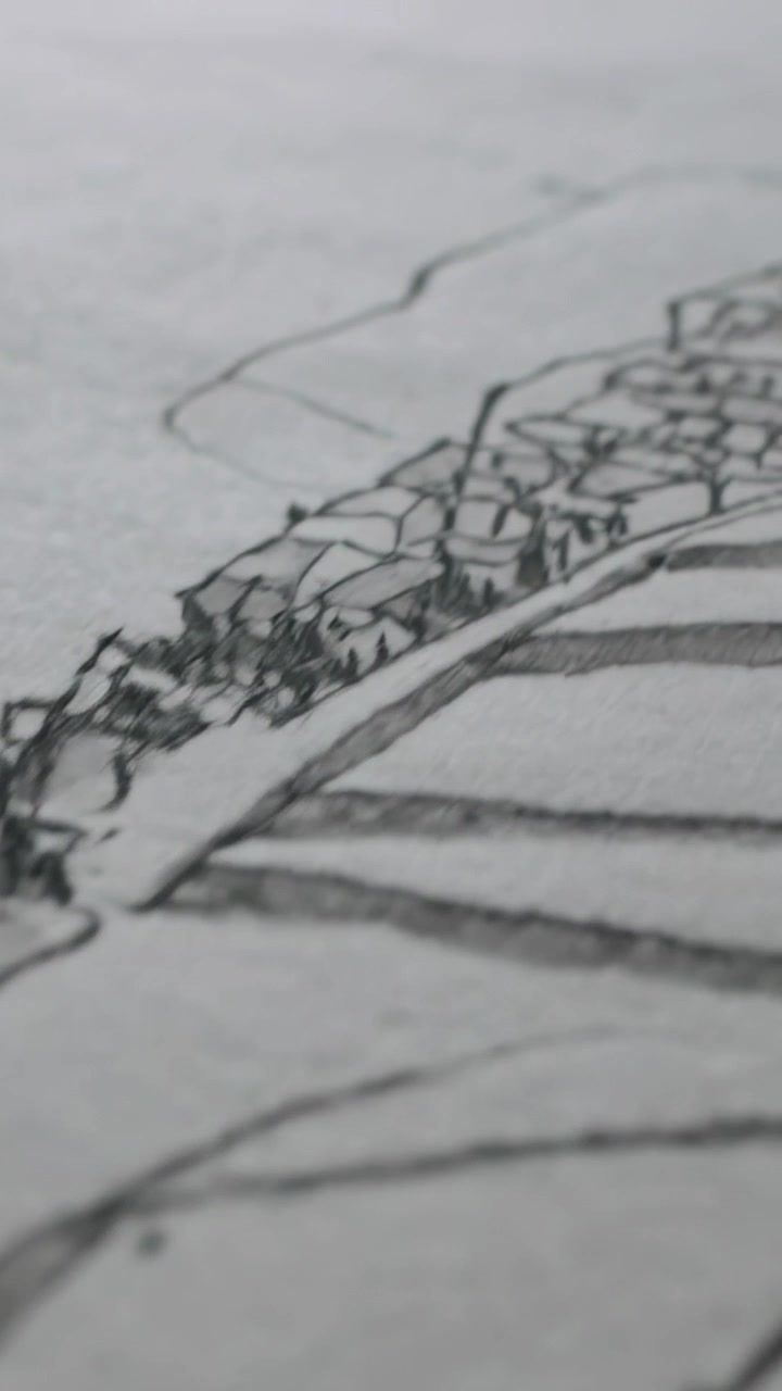 Vertical video: Panning camera revealing sketch on heavy paper at desk, with contours and buildings