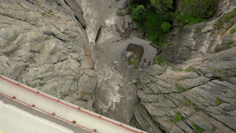 aerial view of a bridge over a rushing river in a rocky canyon