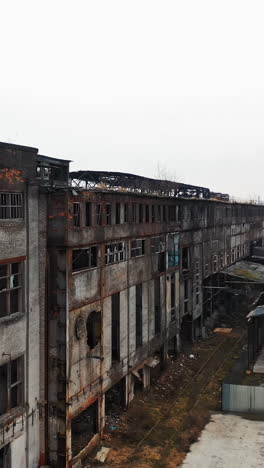 aerial view of an old factory ruin and broken windows. old industrial building for demolition. vertical video