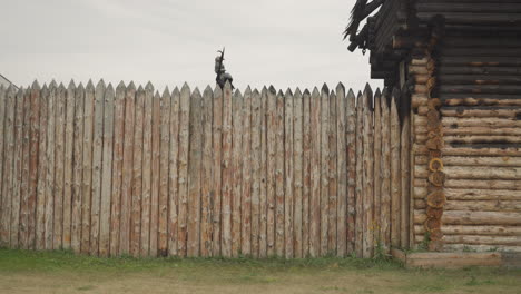 Warrior-patrols-border-of-settlement-walking-along-fence