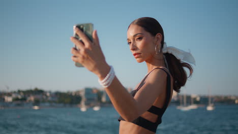 una mujer tomando una selfie junto al océano.