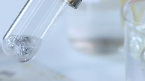 a detailed view of gas bubbles forming in a tilted test tube during a chemical reaction.