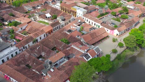 moving inward, the town’s historic architecture unfolds, revealing narrow streets lined with centuries-old buildings and vibrant, flowering trees.