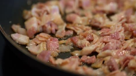 lonchas de tocino picadas chisporrotean y burbujean en una sartén, cocina cinematográfica de cerca