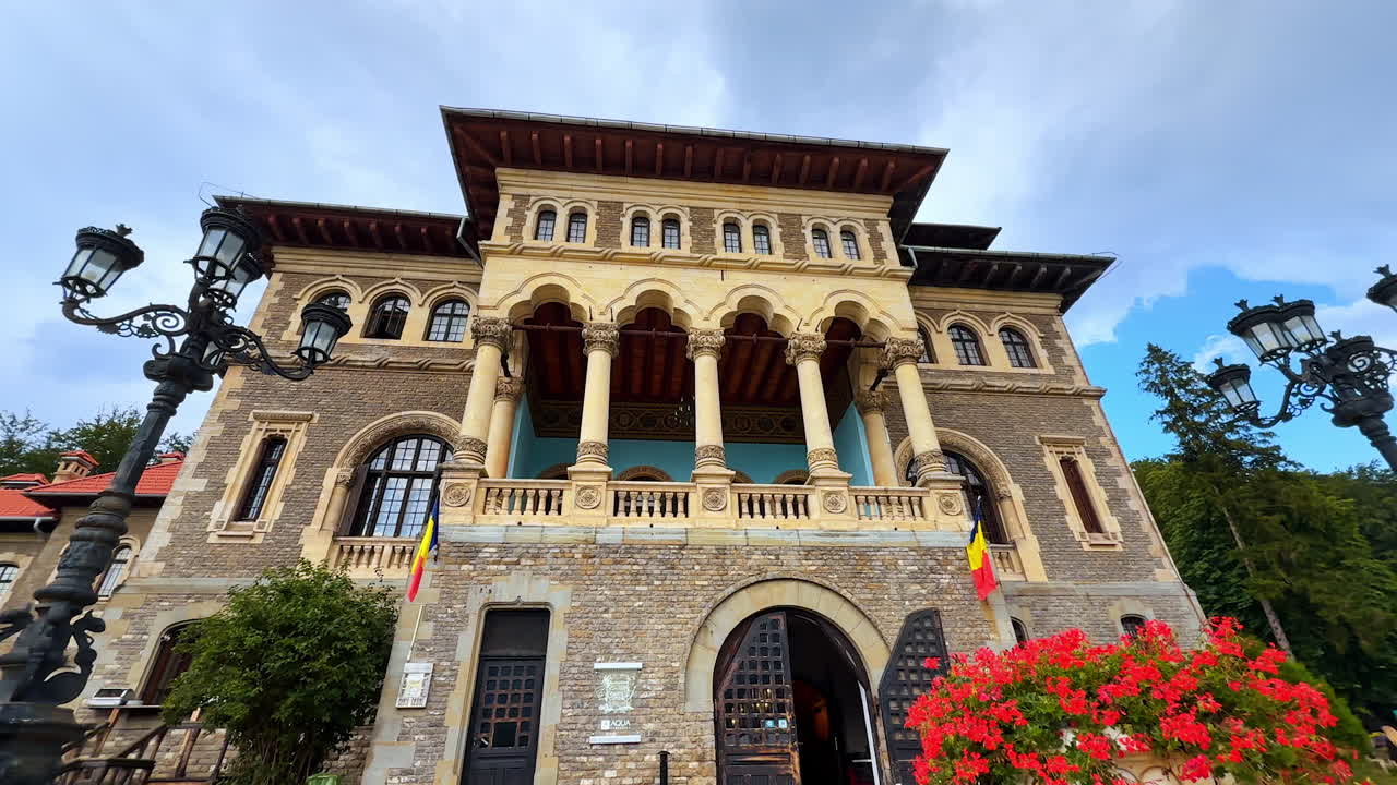 Busteni, Romania, 17 July 2025: Doors open to a famous Cantacuzino Castle in Busteni, Romania. Group of people comes up to a building. Low angle view