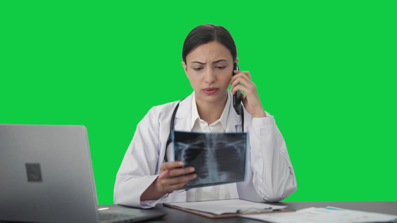 doctora india explicando rayos x al paciente en la pantalla verde de llamada