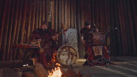 folk band performs on stage decorated with rough logs