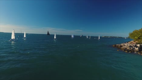 Carrera-De-Veleros-Mientras-La-Cámara-Se-Aleja-Sobre-La-Costa-De-Cayo-Hueso,-Florida,-En-Nítido-4k