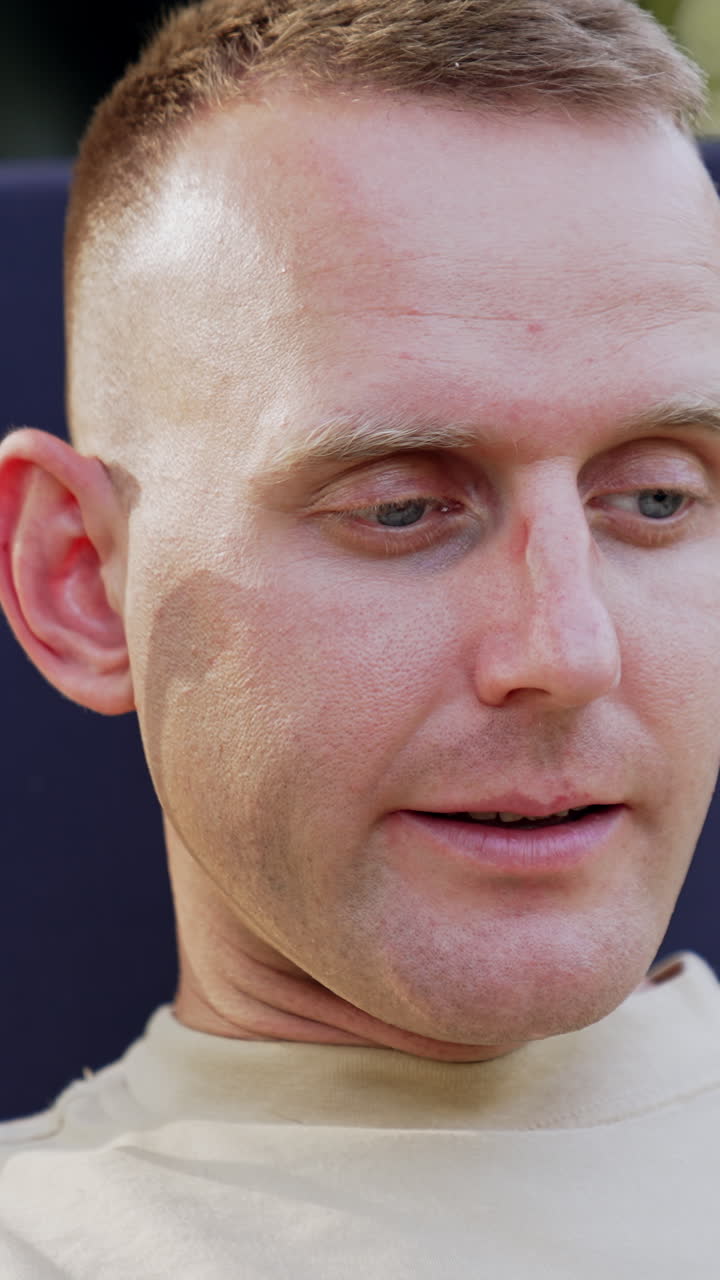 Puzzled man looks at laptop screen waving head disapprovingly. Freelancer working outdoors having some difficulties in work. Vertical video