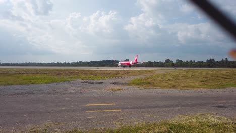 red airasia plane on an airfield