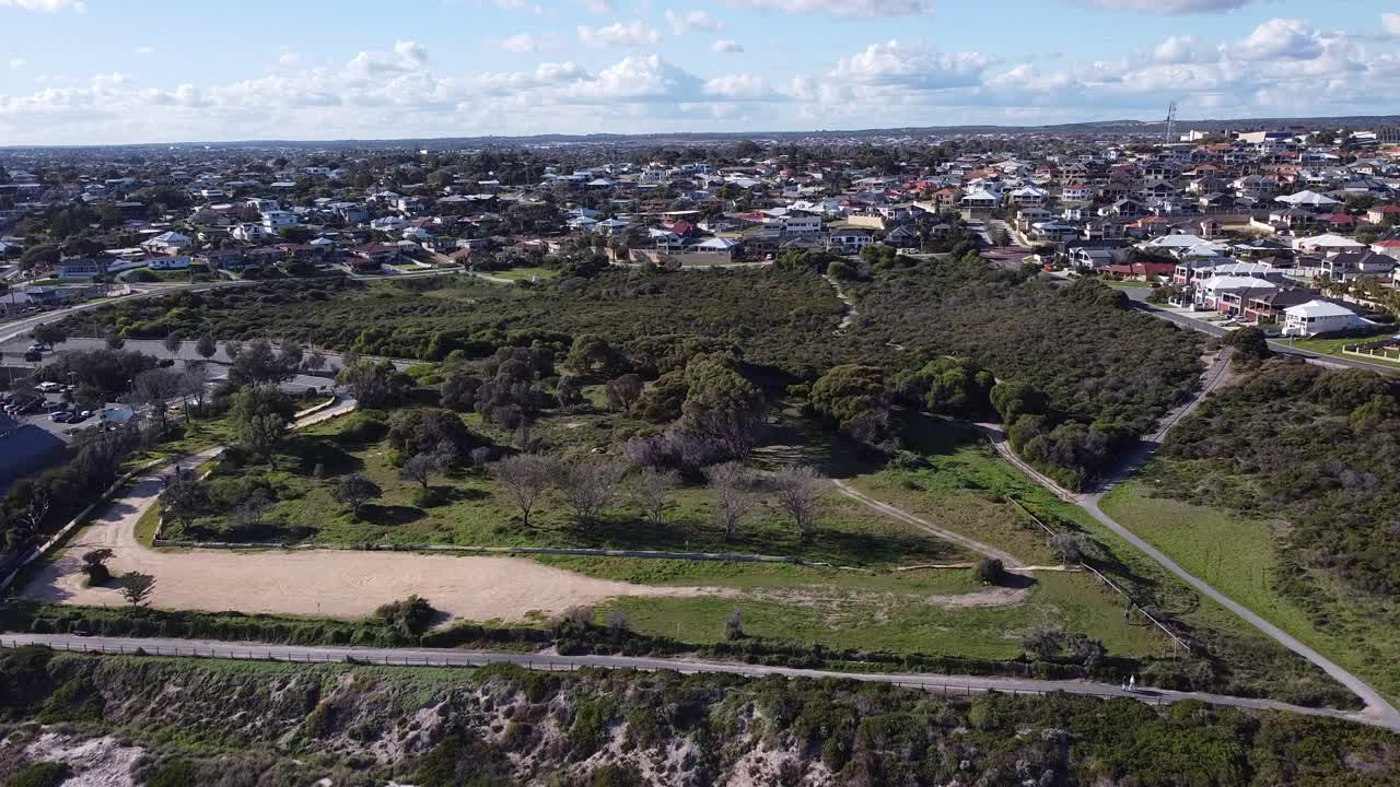levantamiento aéreo disparado sobre quinns rocks antiguo sitio de caravanas, con ciclistas usando el camino costero