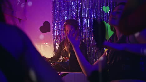 Happy people dancing nightclub enjoying festive atmosphere. DJ mixing music