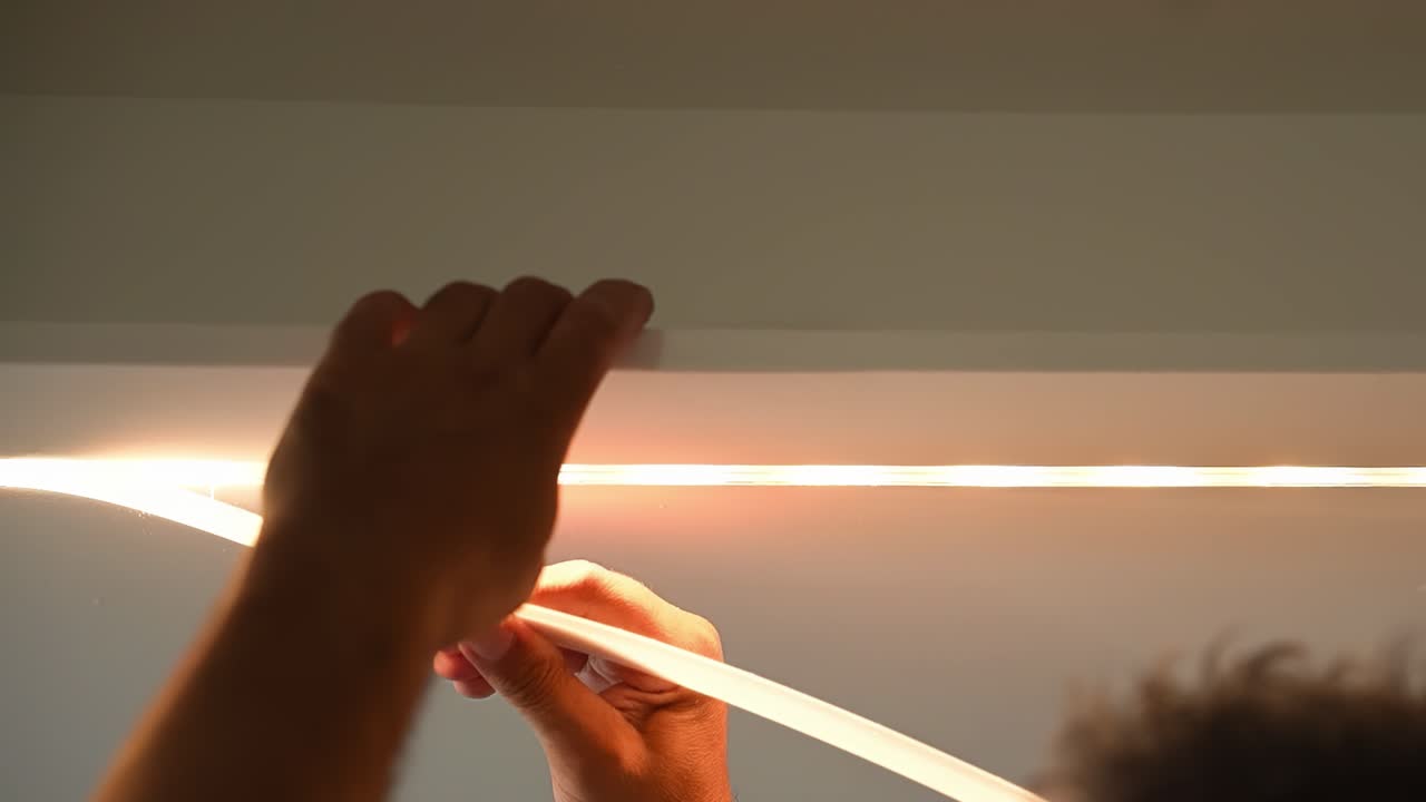 남성 근로자는 노란색 따뜻한 조명, 조명 설치로 led 스트립을 설치합니다.