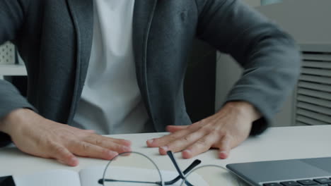 man at a desk, hands gesturing